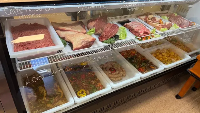 O balcão do Costa's Meat Market em Davenport, FL, com carne moída, maminha, alcatra, costela, bifes, linguiça caseira e carnes temperadas