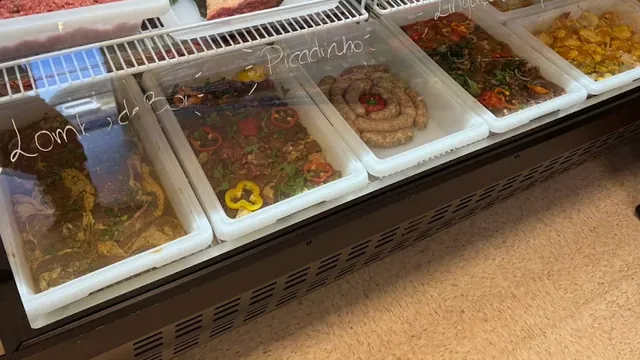 Carnes sazonadas listas para cocinar: lomo de cerdo, picadinho, linguiça y pollo en Costa's Meat Market